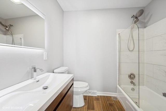 bathroom with toilet, wood finish floors, vanity, visible vents, and tub / shower combination