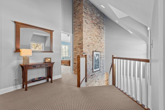 corridor featuring carpet, high vaulted ceiling, and baseboards