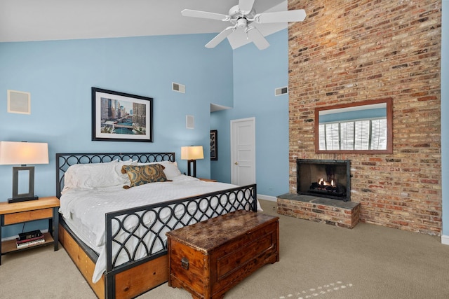 carpeted bedroom featuring ceiling fan, a brick fireplace, visible vents, and baseboards