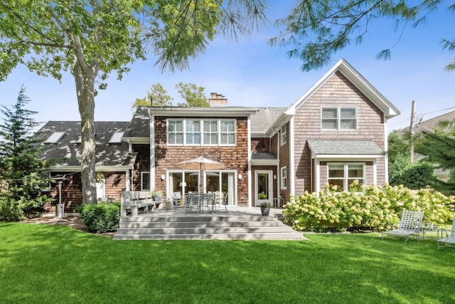back of property with a lawn, a chimney, and a wooden deck