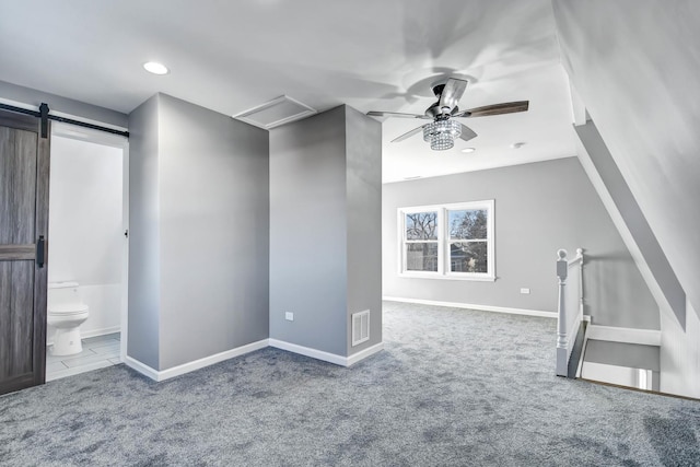 interior space featuring carpet, visible vents, baseboards, and a barn door