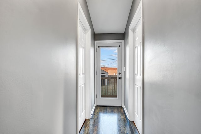 doorway featuring dark wood finished floors and baseboards