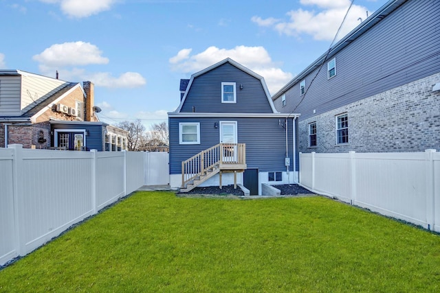 back of house with a fenced backyard, a lawn, and a gambrel roof