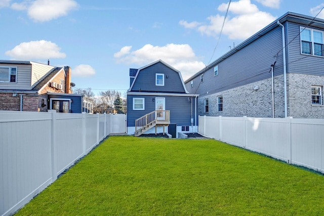 back of house with a yard, a fenced backyard, and a gambrel roof