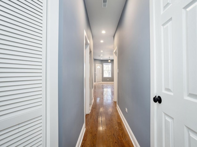 hall with dark wood-type flooring, recessed lighting, visible vents, and baseboards