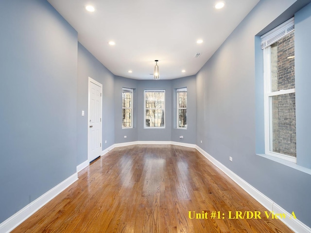 spare room featuring recessed lighting, wood finished floors, and baseboards