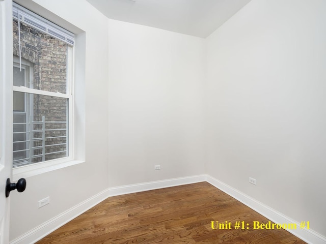 unfurnished room featuring baseboards and wood finished floors