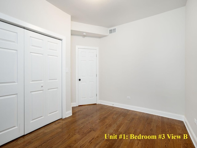 unfurnished bedroom featuring a closet, wood finished floors, visible vents, and baseboards