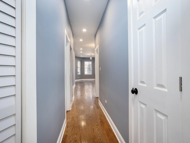 hallway featuring recessed lighting, baseboards, and wood finished floors