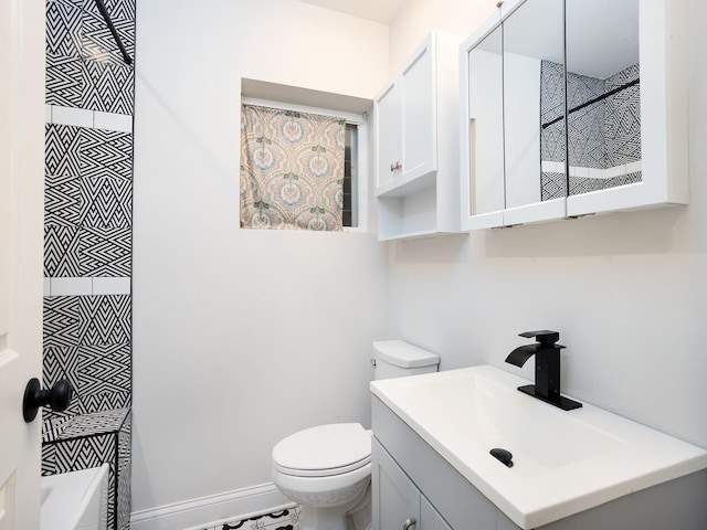 bathroom with baseboards, vanity, and toilet