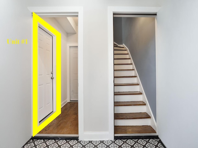 staircase with baseboards and tile patterned floors