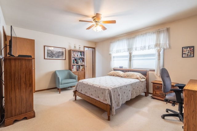 bedroom with light colored carpet, ceiling fan, and baseboards