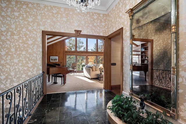 hallway featuring crown molding, an inviting chandelier, and wallpapered walls