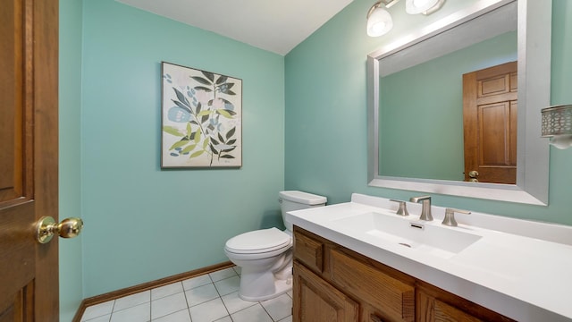 half bathroom with toilet, tile patterned flooring, baseboards, and vanity