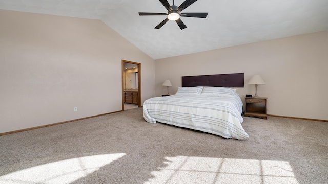 bedroom with vaulted ceiling, baseboards, ensuite bath, and light colored carpet