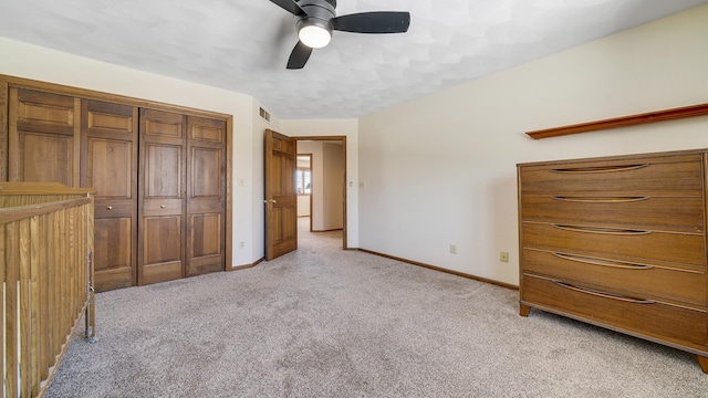 unfurnished bedroom with a closet, visible vents, light carpet, ceiling fan, and baseboards