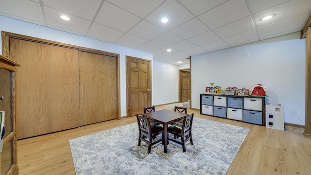 dining area featuring light wood-type flooring, a drop ceiling, baseboards, and recessed lighting