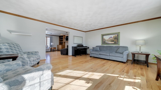 living room with light wood-type flooring, a fireplace, and ornamental molding