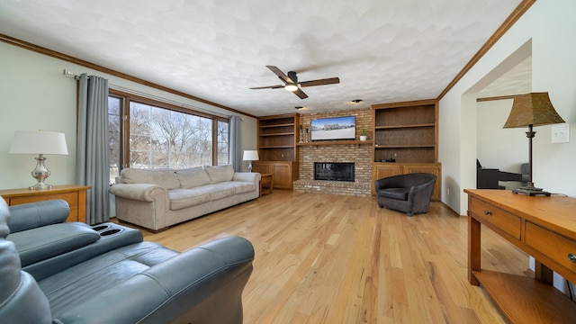 living area featuring a textured ceiling, ceiling fan, a fireplace, light wood finished floors, and crown molding