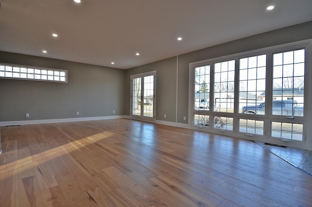 unfurnished room with light wood finished floors, visible vents, baseboards, and recessed lighting