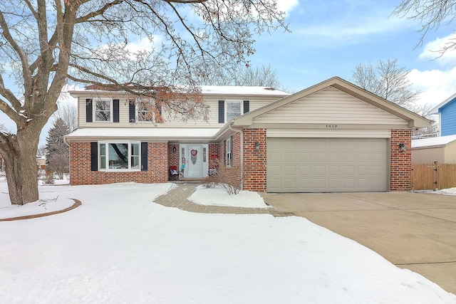 view of front facade with a garage, brick siding, concrete driveway, and fence