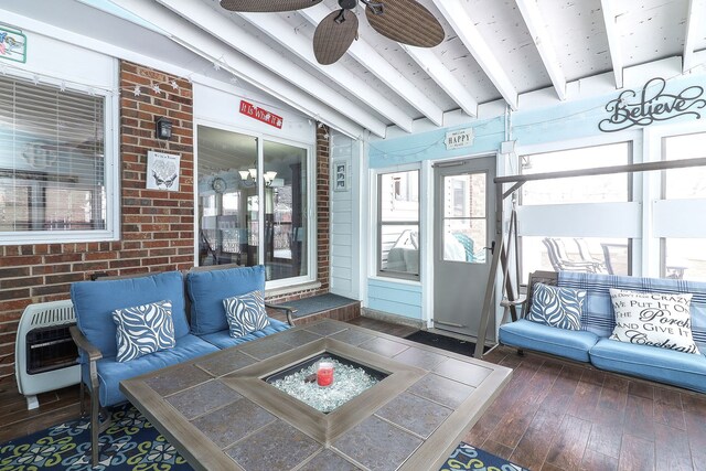 sunroom / solarium with heating unit, vaulted ceiling with beams, and ceiling fan