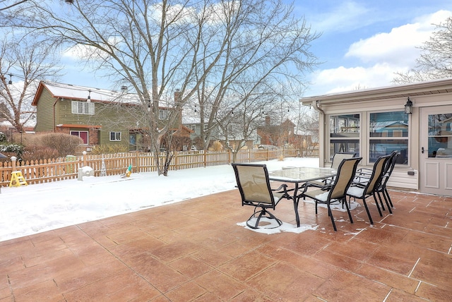 snow covered patio featuring fence private yard and outdoor dining area