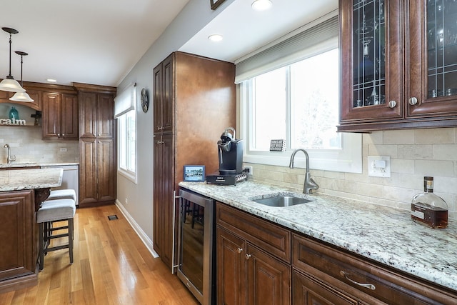 kitchen with wine cooler, pendant lighting, stainless steel dishwasher, and a sink