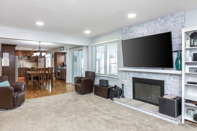 living area with recessed lighting, an inviting chandelier, a fireplace, and carpet flooring