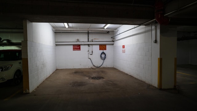 below grade area featuring a garage, washer / clothes dryer, and concrete block wall