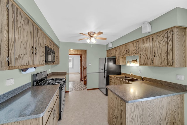 kitchen with stainless steel appliances, dark countertops, brown cabinetry, and a sink