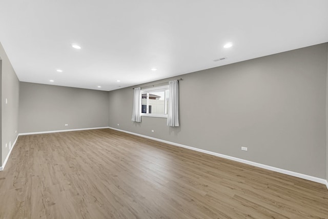 empty room featuring light wood-style floors, baseboards, visible vents, and recessed lighting