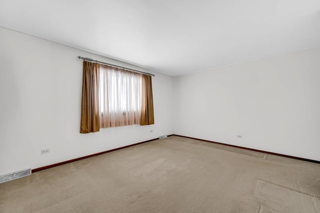 spare room featuring baseboards, visible vents, and carpet flooring