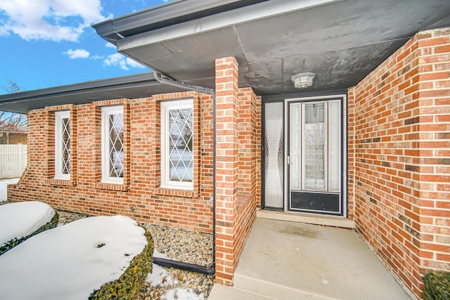 doorway to property with brick siding