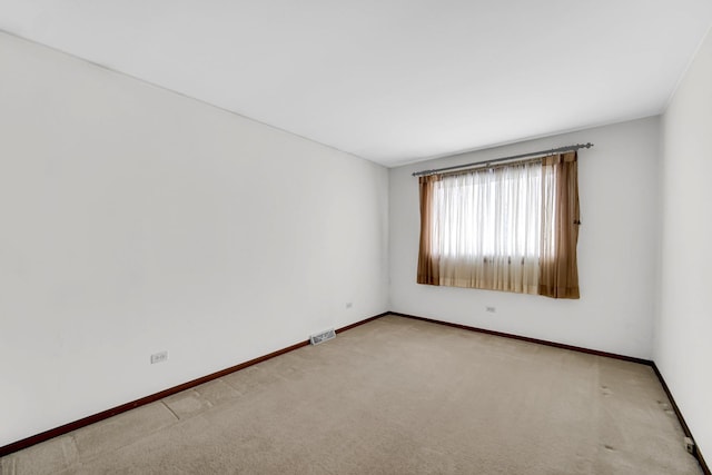 unfurnished room featuring light carpet, visible vents, and baseboards