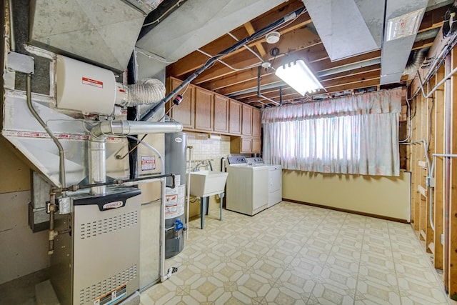 below grade area with light floors, washing machine and dryer, baseboards, and a sink