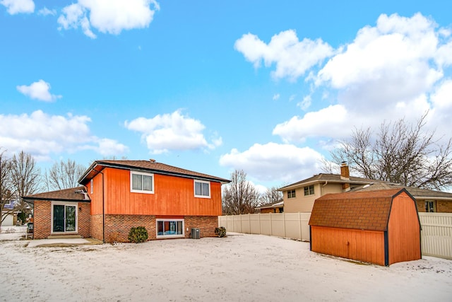 view of home's exterior with an outbuilding, brick siding, fence, a shed, and cooling unit