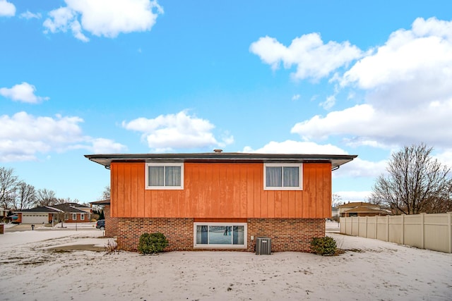 rear view of house featuring fence and brick siding