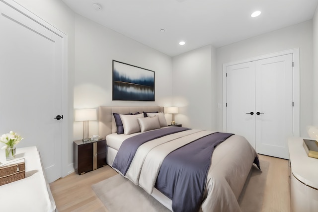 bedroom with recessed lighting, a closet, and light wood finished floors