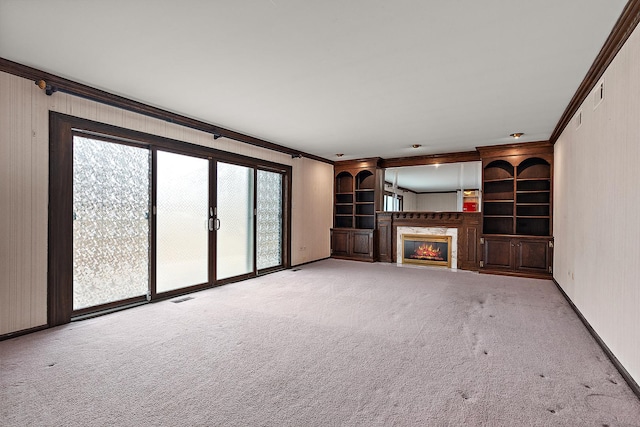 unfurnished living room with a fireplace, carpet flooring, visible vents, baseboards, and ornamental molding