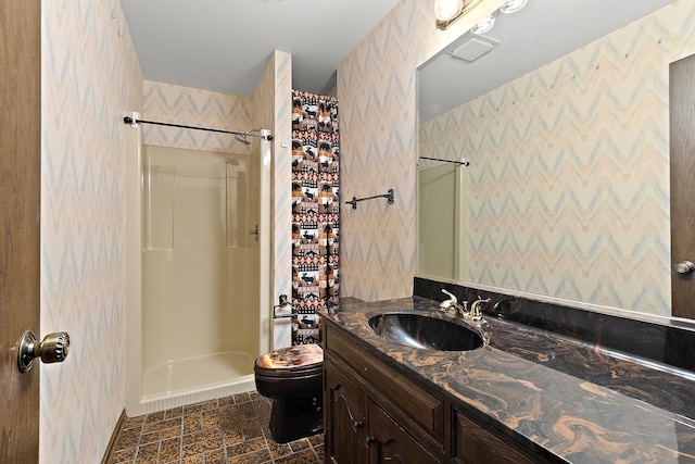 bathroom with a shower, vanity, and toilet