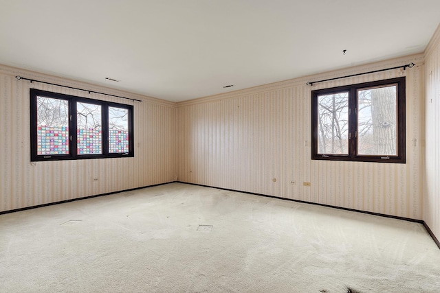 empty room featuring light carpet, a wealth of natural light, and wallpapered walls