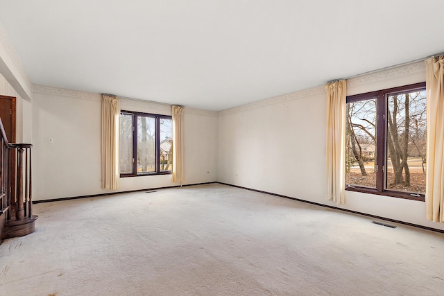 unfurnished living room with carpet floors, visible vents, and baseboards