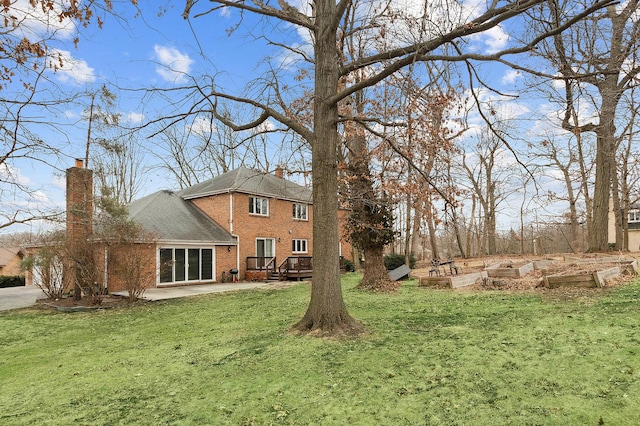 exterior space featuring a patio, driveway, a vegetable garden, and a wooden deck