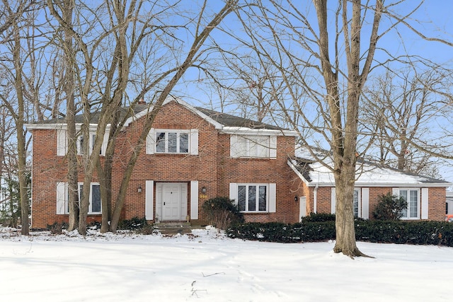 colonial-style house with brick siding