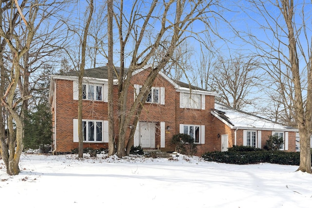 colonial-style house featuring brick siding