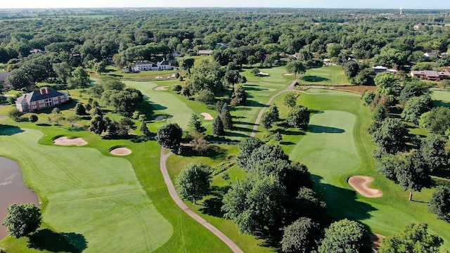 birds eye view of property with view of golf course and a view of trees