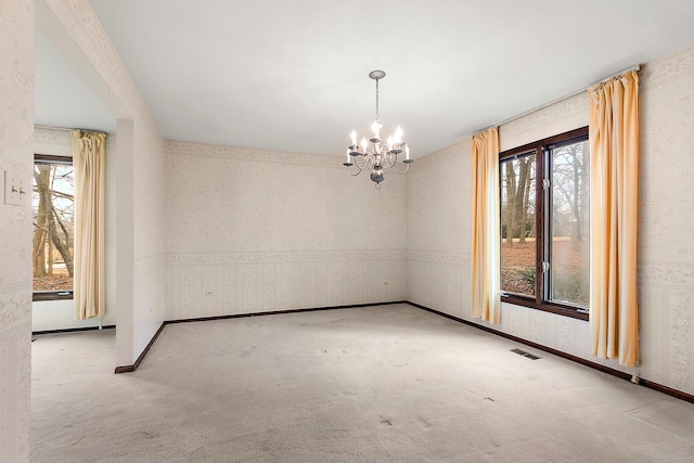 spare room with visible vents, carpet flooring, a chandelier, baseboards, and wallpapered walls