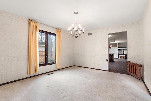 unfurnished room featuring an inviting chandelier, visible vents, carpet flooring, and wallpapered walls