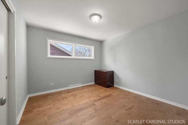 empty room featuring baseboards and light wood finished floors